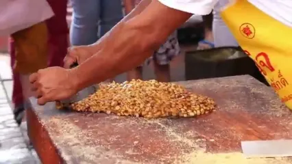 غذای خیابانی در تایلند؛ تهیه آب نبات بادام زمینی در بانکوک