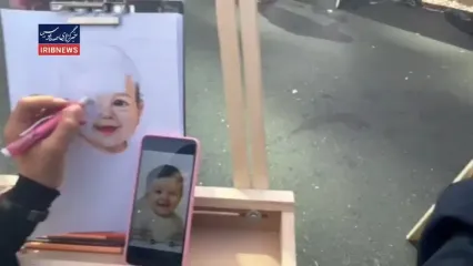 خلق تصاویر شهدای کودک دفاع مقدس ۱۲ روزه به‌دست دانش‌آموزان در حاشیه راهپیمایی ۱۳ آبان