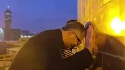 گریه خادمان هنگام تعویض پرچم امام رضا(ع)
