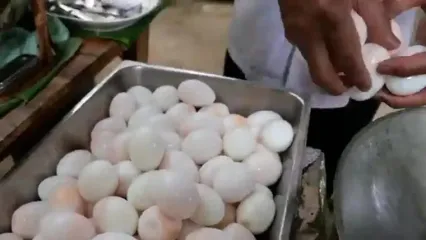غذای خیابانی در تایلند؛ پخت غذا با تخم اردک آب پز شده، زنجبیل، برنج و فلفل در بانکوک